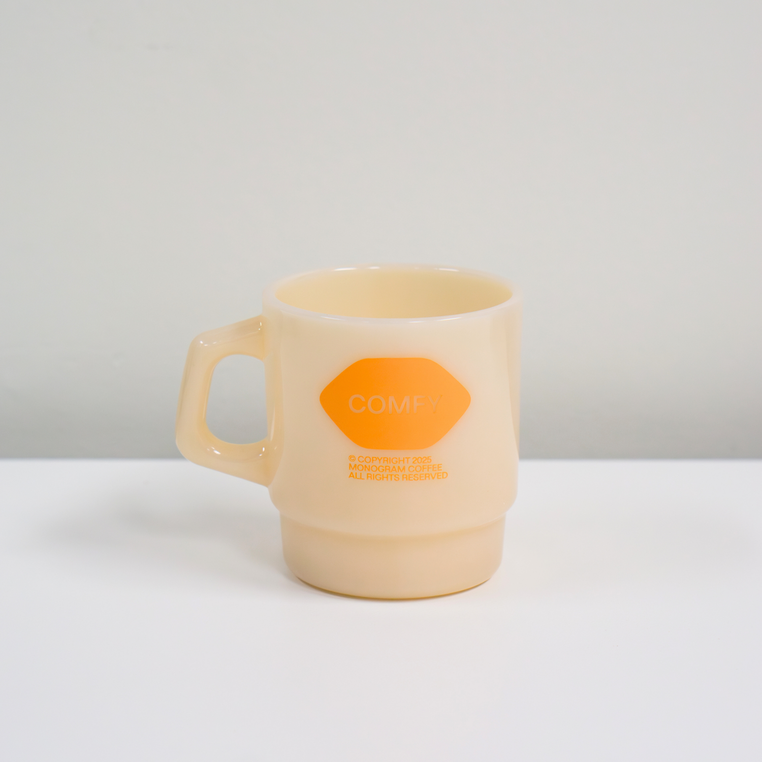 Beige mug with an orange logo on a white background