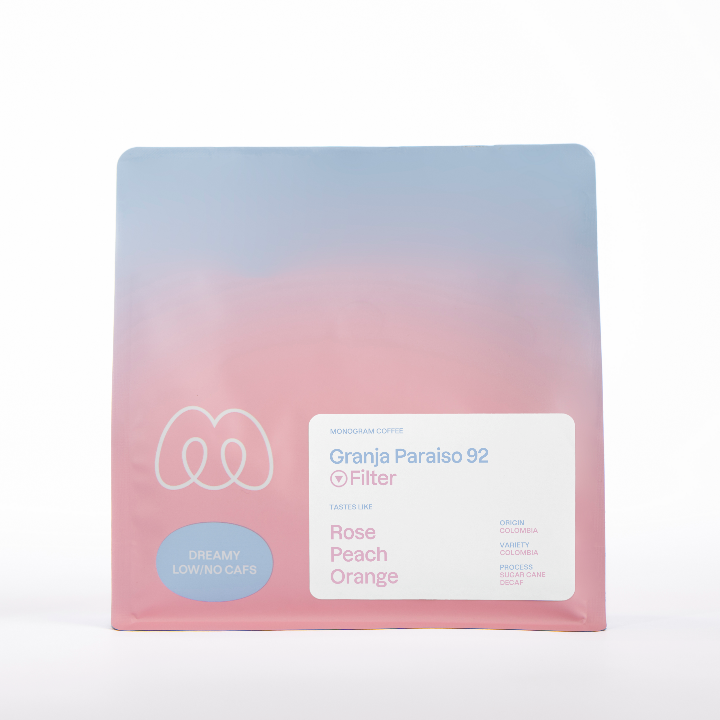 A blue and pink gradient bag of Monogram Granja Paraiso 92 filter coffee, a Sugar Cane process decaf from Colombia with tasting notes of rose, peach, and orange