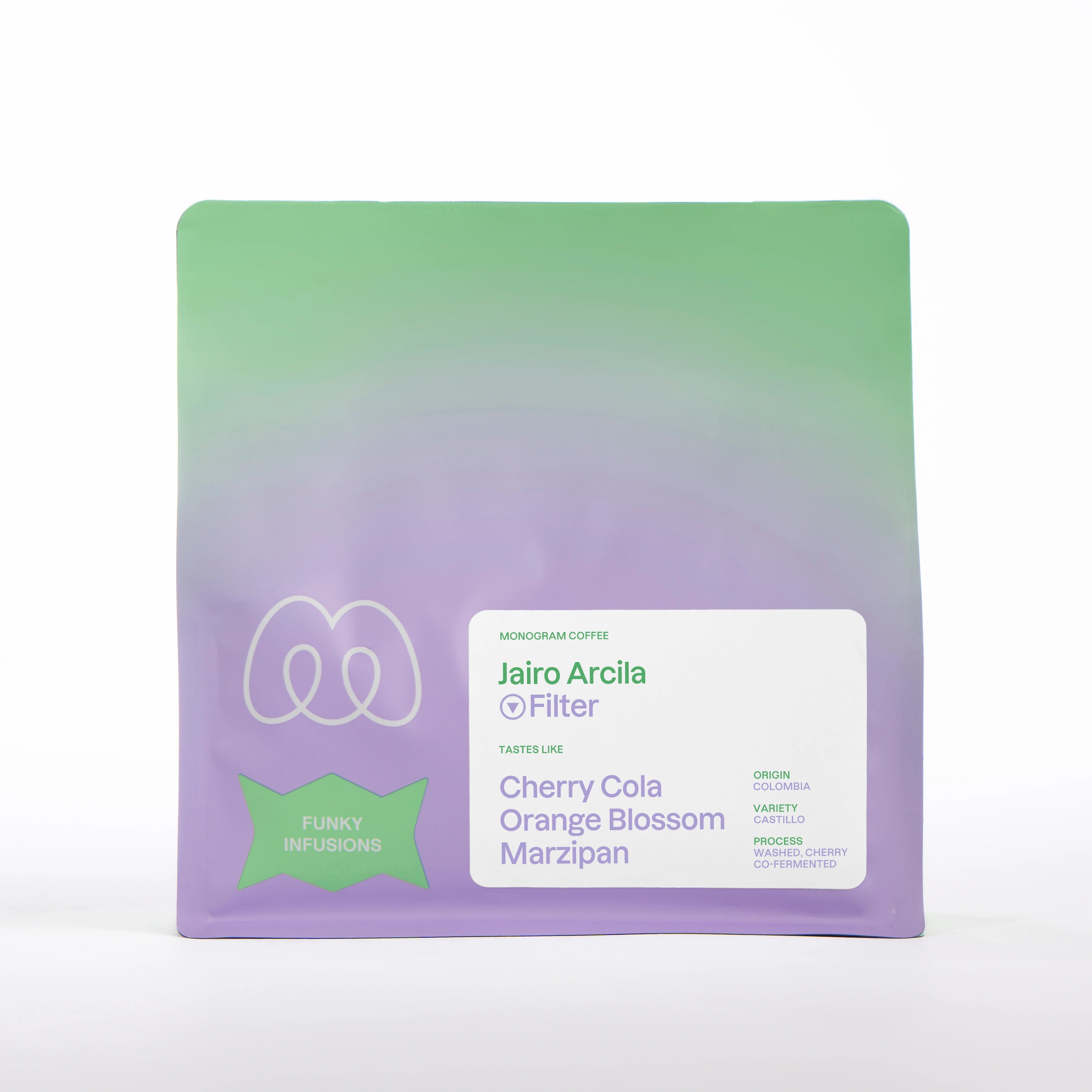 A purple and green gradient bag of Monogram Jairo Arcila filter coffee, a washed cherry co-fermented Castillo variety from Colombia with tasting notes of cherry cola, orange blossom, and marzipan.