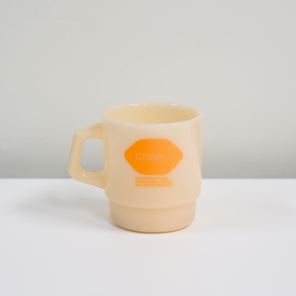 Beige mug with an orange logo on a white background