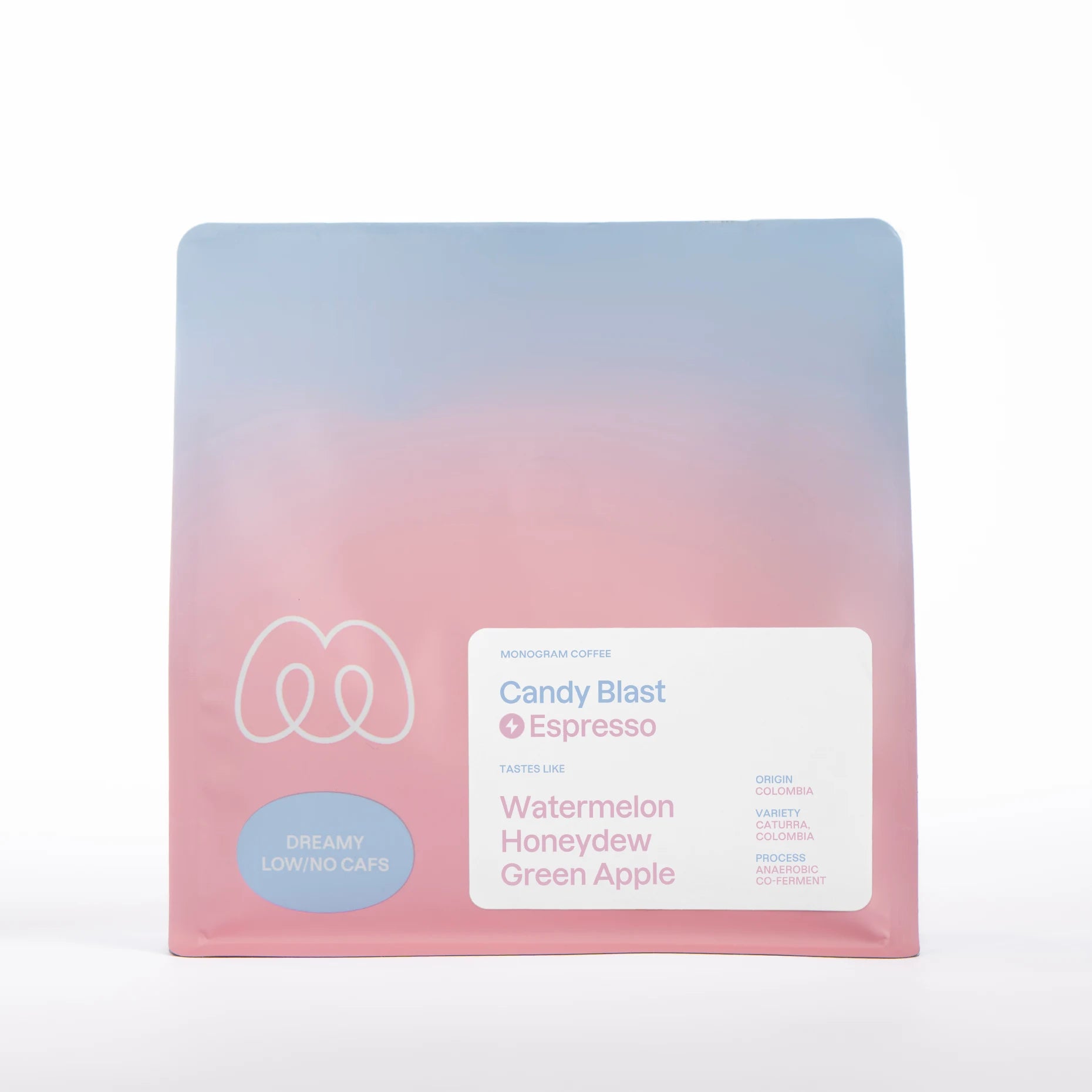 A blue and pink gradient bag of Monogram Candy Blast decaf espresso, an anaerobic co-ferment from Colombia (Caturra and Colombia varieties) with tasting notes of watermelon, honeydew, and green apple.