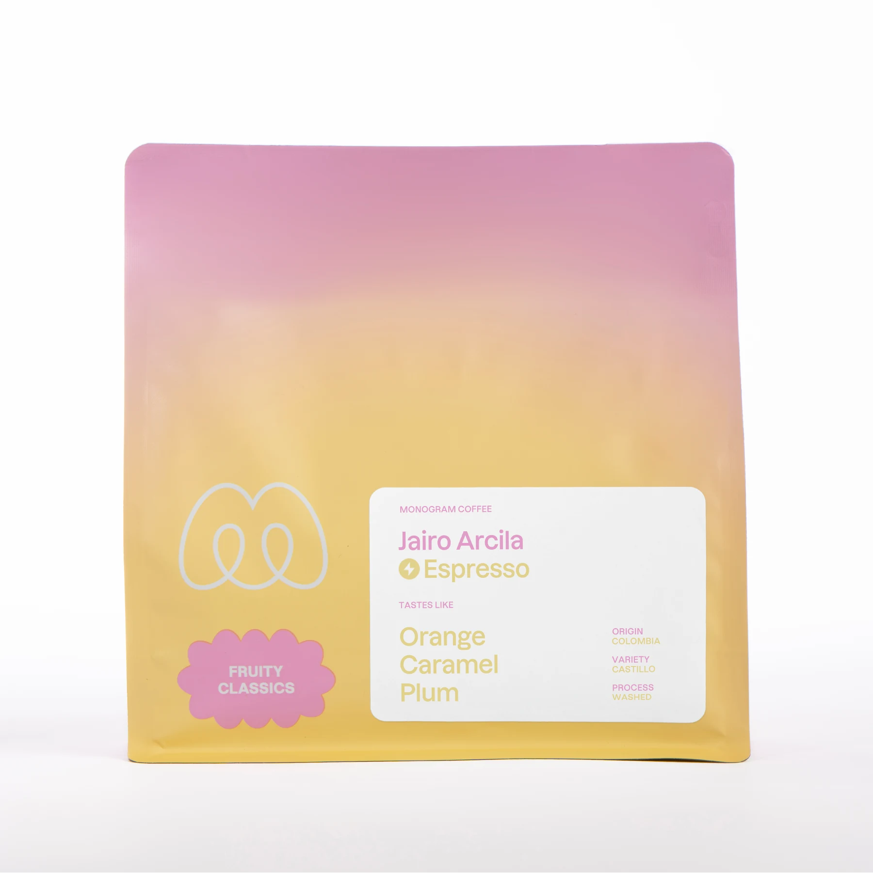 A pink, orange, and yellow pastel gradient bag of Monogram Jairo Arcila espresso, a washed processed Castillo variety from Colombia with tasting notes of orange, caramel, and plum.